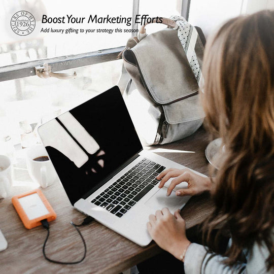 A woman on a Mac at a desk outlining a Marketing plan.