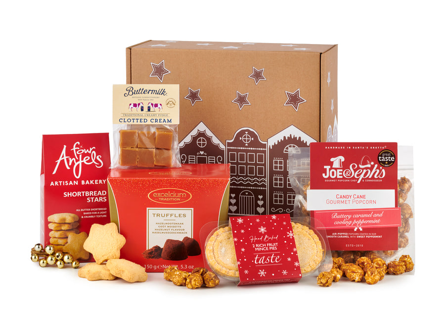 The christmas gift box by spicers of hythe. Packaged into a decorative gift box with stars & gingerbread style houses on top. Mince pies, truffles, candy cane popcorn, shortbread stars & more sweet food products are inside this festive gift box.